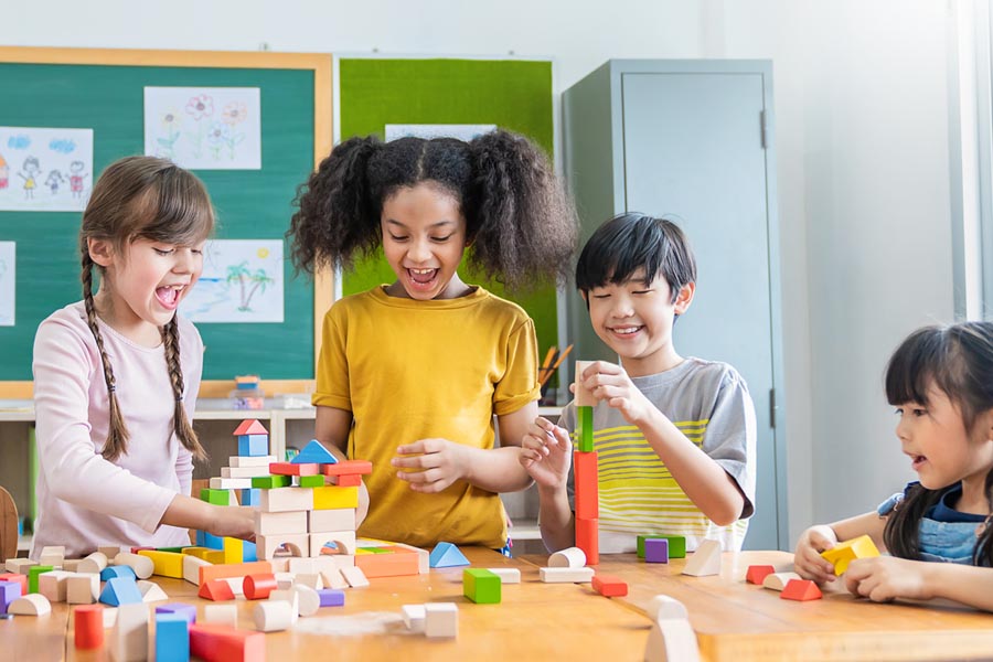 A group of happy kids immersed in cooperative play with building blocks