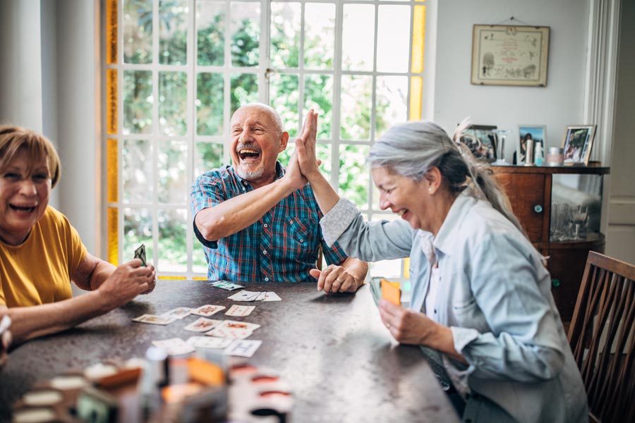 Older adults laughing over a card game